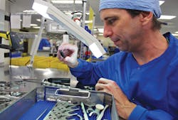 Duane Mattingly, Instrument Tech II, inspects an instrument using a table top magnifier. Duane Mattingly, Instrument Tech II, inspects an instrument using a table top magnifier.