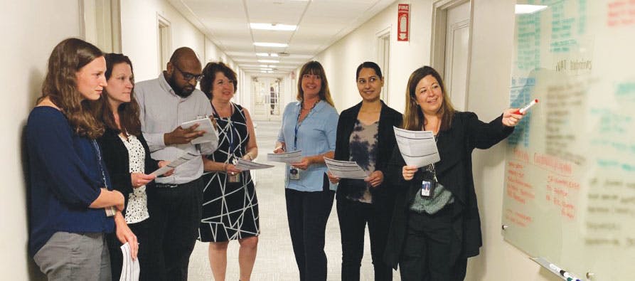 Jennifer Killinger, Clinical Resource Manager, leading the OR daily huddle with (from left to right) Miranda Carfagno, Theresa Meitzler, Chinnaiah Naidu, Lori Stoudt, Stacy Stiles, &amp; Pavinder Mangat