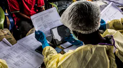 Health workers fill paper form before vaccinating people who have been in touched with other people who got Ebola infected. Photo: World Bank / Vincent Tremeau
