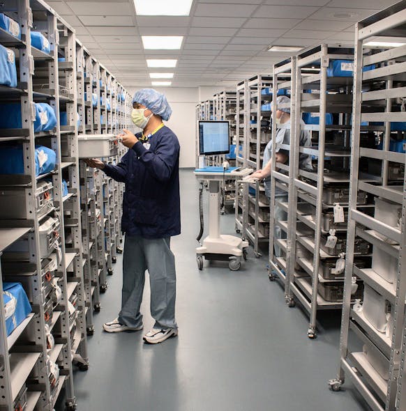 Bernard Bingayen and Kate Mayer put sterile trays away and scan them to location shelves on DSI storage racks.