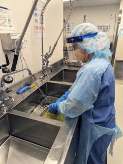 Jessica Kueteman manually cleaning a tray Jessica Kueteman manually cleaning a tray